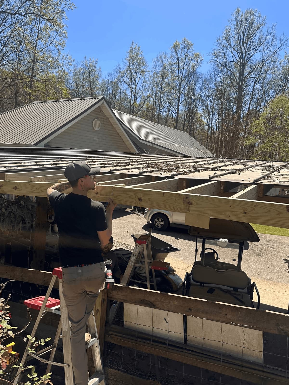 Electrician on ladder working on framing